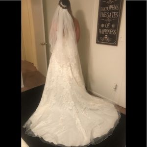 Wedding dress with veil, belt, and hairpiece.
